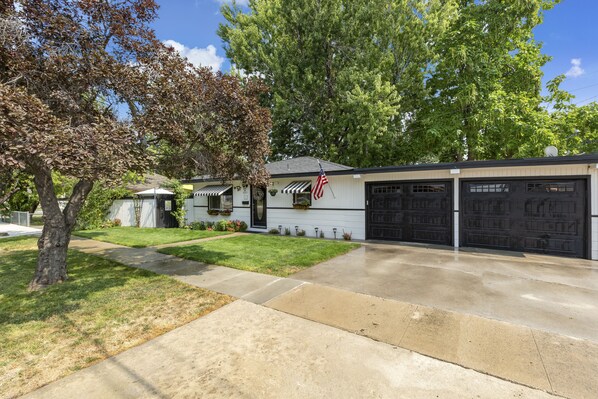 A two-story house with a garage, a front lawn, and a tree. - ENJOY THE HISTORY, NOSTALGIA AND CULTURE OF OLD TOWN MERIDIAN (Meridian)
