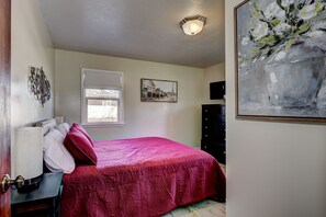 A bedroom with a bed, a dresser, a lamp, a window, and a painting on the wall. - ENJOY THE HISTORY, NOSTALGIA AND CULTURE OF OLD TOWN MERIDIAN (Meridian)