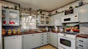 A kitchen with white cabinets, a stove, a microwave, and a dishwasher. - ENJOY THE HISTORY, NOSTALGIA AND CULTURE OF OLD TOWN MERIDIAN (Meridian)