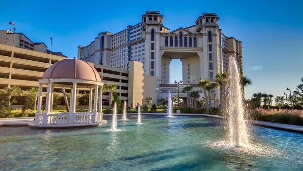 Un hôtel doté d’une grande fontaine, d’un belvédère et surplombant un ciel d’un bleu limpide.
