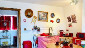 A cozy kitchen with a dining table, chairs, and a red trash bin. - The Barn, mini petting zoo mid term 1-6 month stays  (Warner Springs)