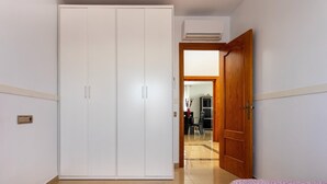 Une pièce avec une armoire, une porte en bois et un sol carrelé.