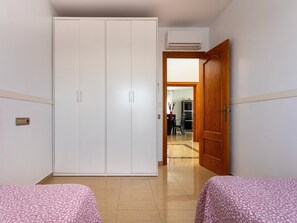A room with a wardrobe, a wooden door, and a tiled floor.