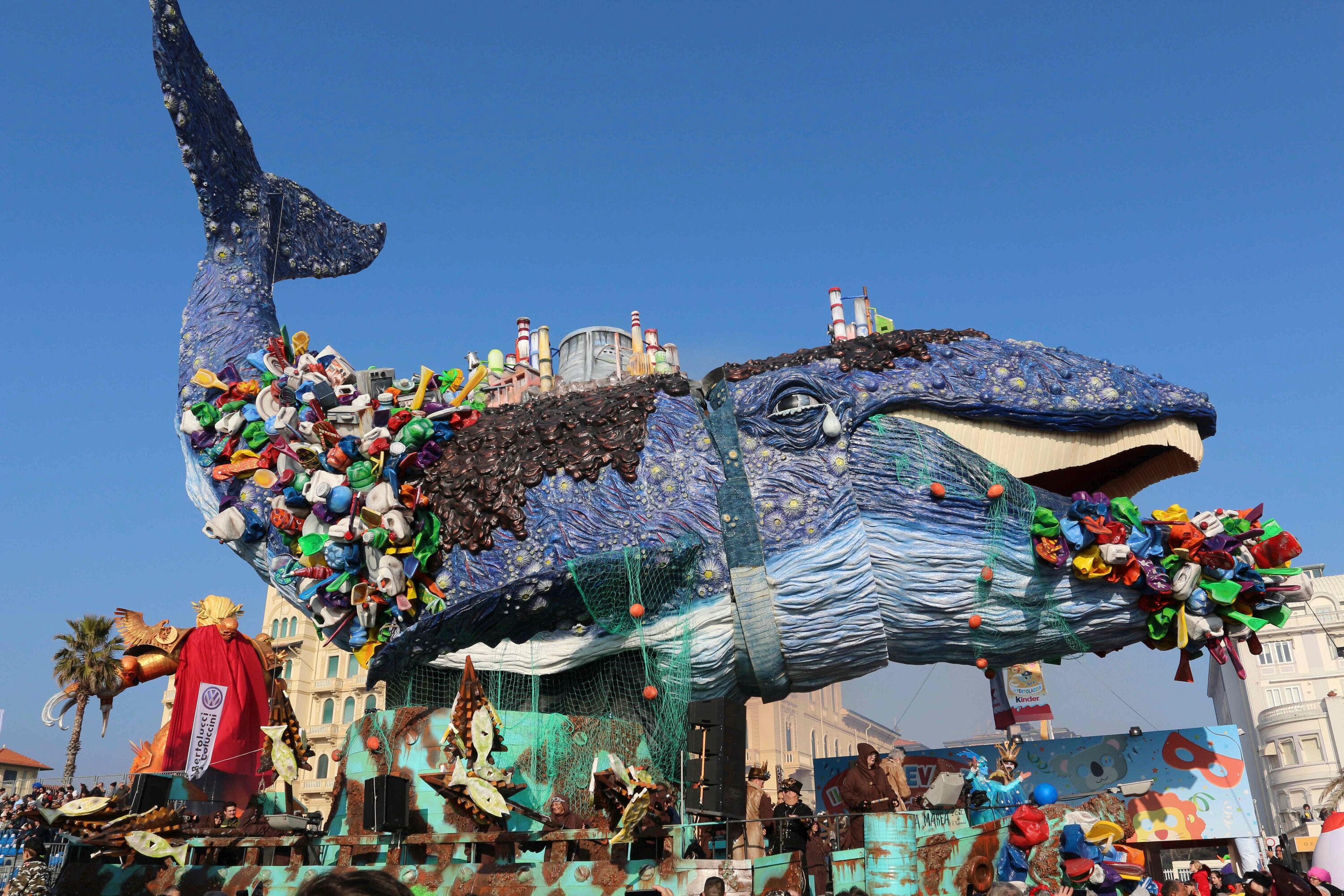 Una escultura grande y colorida de una ballena con varios objetos adheridos.