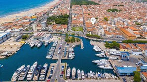 A marina with numerous boats docked, a coastal cityscape with buildings, and a beach in the background. - Suite Ondina Viareggio Apartments (Viareggio)