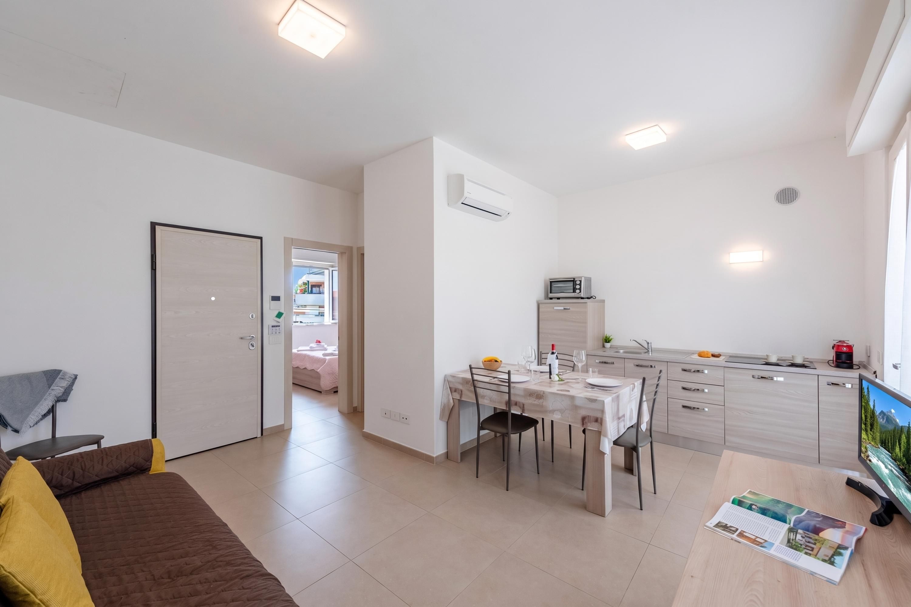 A modern apartment with a dining area, kitchen, and a living room.