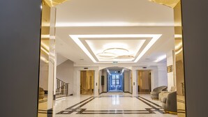 A modern hotel lobby with a marble floor, a central light fixture, and a reception desk. - Aileena Hotel & Villas (Kartepe)