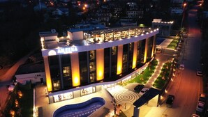 A modern hotel with a curved facade, large windows, and a central courtyard. - Aileena Hotel & Villas (Kartepe)