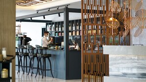 A modern bar area with a bartender, bar stools, and shelves of bottles. - Aileena Hotel & Villas (Kartepe)