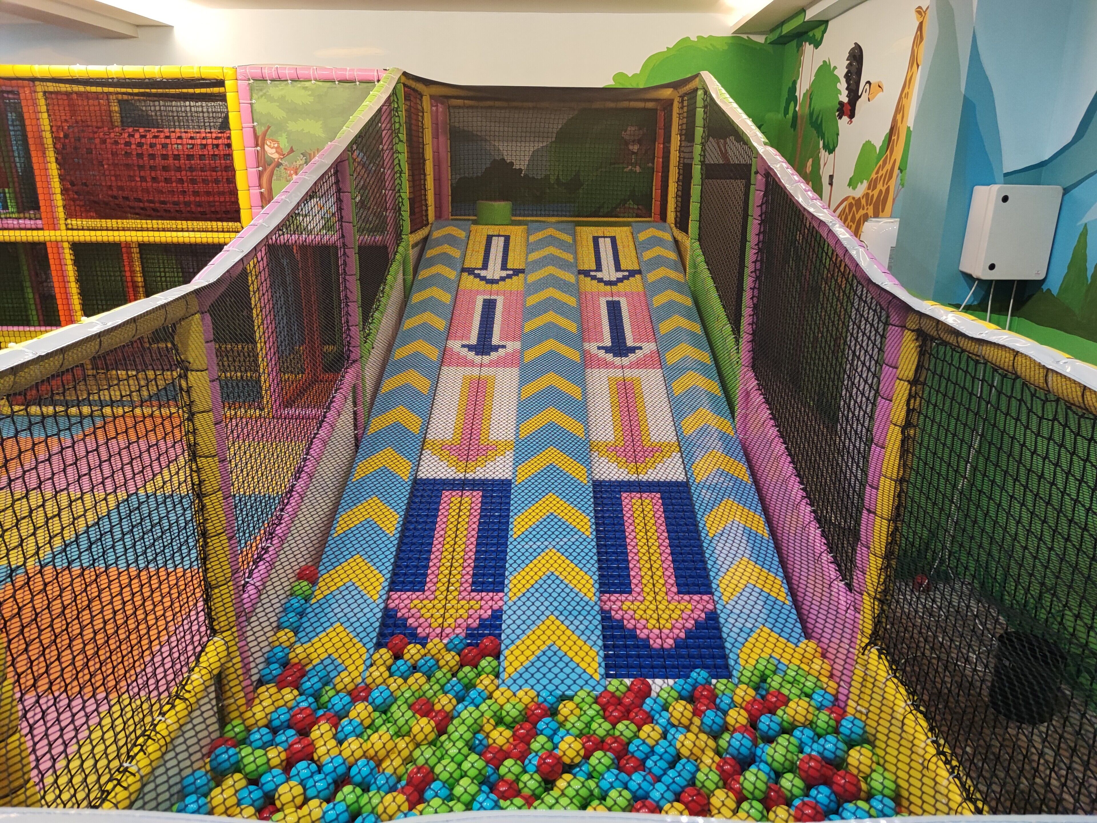 A colorful indoor play area with a slide and ball pit.