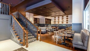 A spacious living area with a staircase, a kitchen, and a dining area. - 16th FL Bold CozySuites w/pool, gym, roof #5 (Dallas)