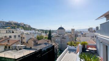 A rooftop terrace with a view of a cityscape, including a prominent church with a dome and a hilltop building.