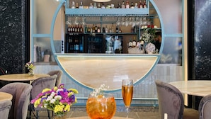 Un restaurant doté d’un bar, avec un comptoir où sont exposées des bouteilles et des verres, ainsi qu’une table où sont servis des plats et des boissons.