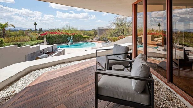 Un patio moderno al aire libre con piscina, zona de estar y vistas al paisaje.