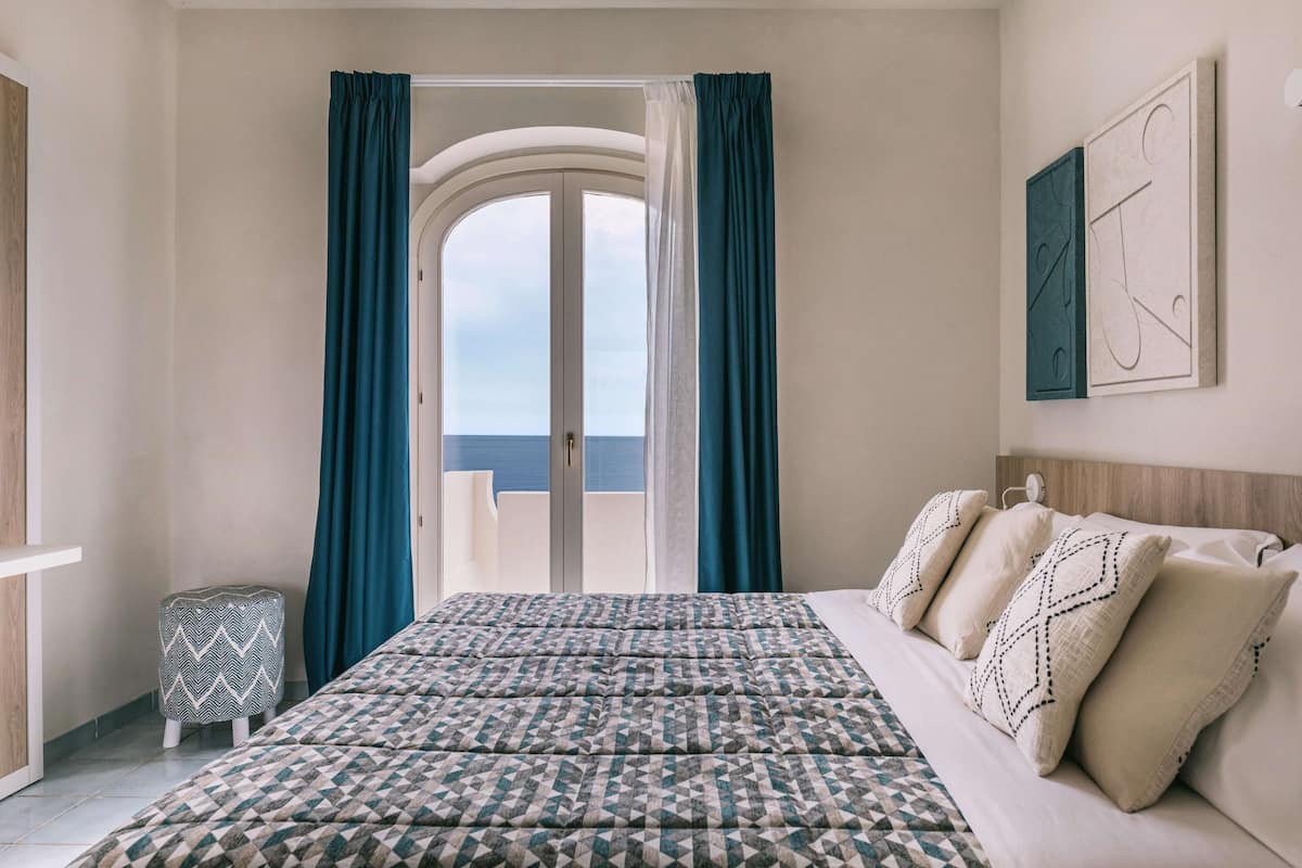 Habitación doble superior, vista al mar | 1 habitación, caja de seguridad en la habitación y ropa de cama