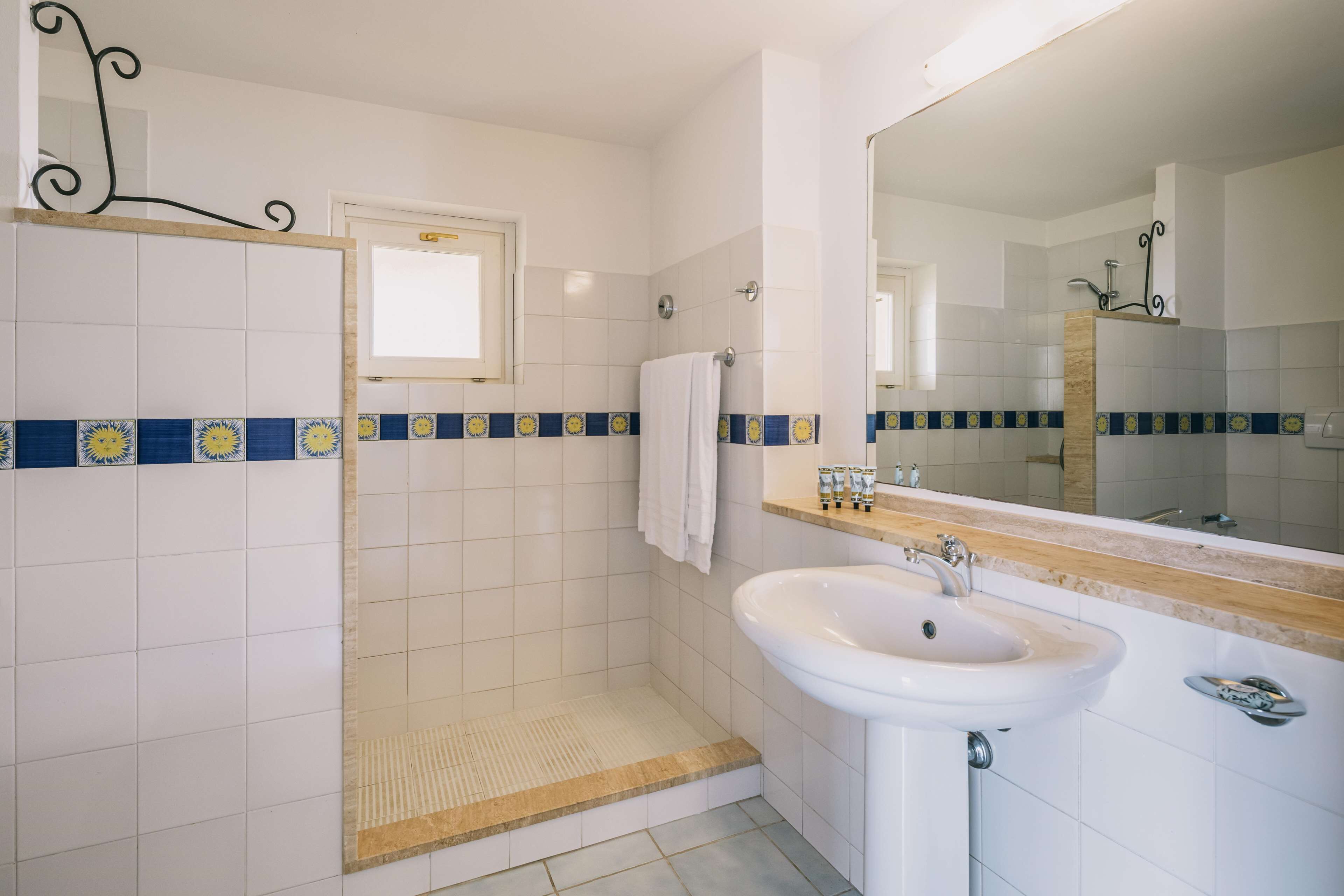 A bathroom with a shower, sink, and mirror.