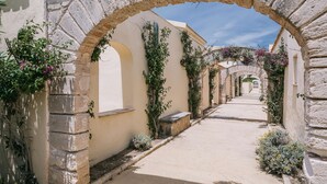 A narrow street with stone arches and buildings on either side. - Mangia's Favignana Resort (Favignana)