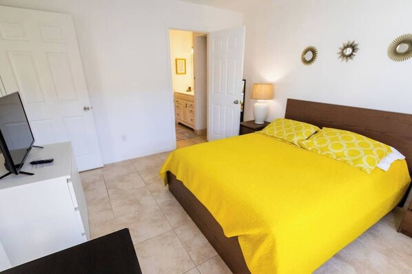 A bedroom with a bed, a desk, a chair, and a door. - 270B - Boca Retreat w/ Pool, Parking, Near Evert Tennis & Shops (Boca Raton)