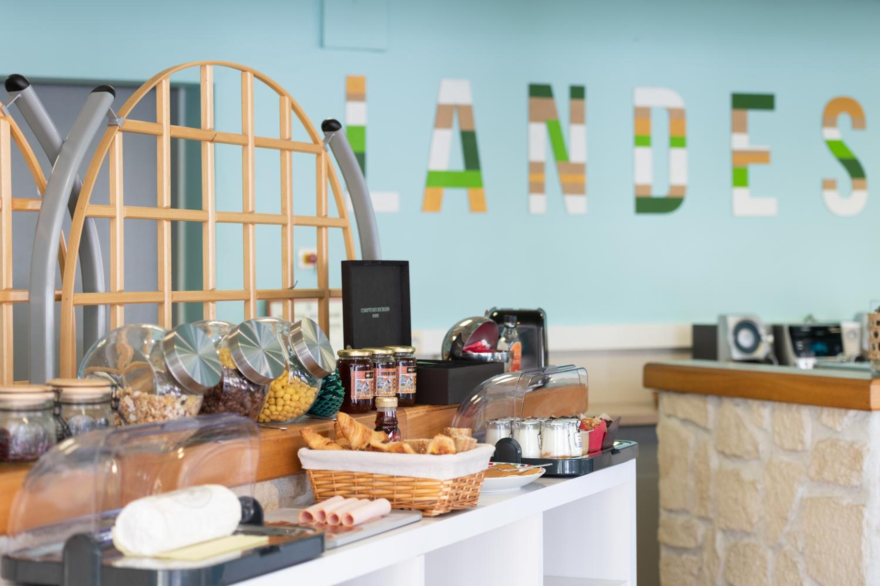 A buffet setup with various food items and condiments, a coffee machine, and a decorative wooden structure.