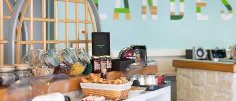 A buffet setup with various food items and condiments, a coffee machine, and a decorative wooden structure.