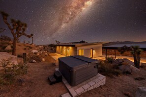 Un bâtiment moderne doté d’un patio, sous un ciel étoilé.