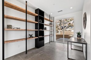 A modern interior with built-in shelves, a black cabinet, and a view through glass doors.