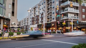 Un immeuble à plusieurs étages qui abrite un restaurant appelé « Bar Louie » au rez-de-chaussée.