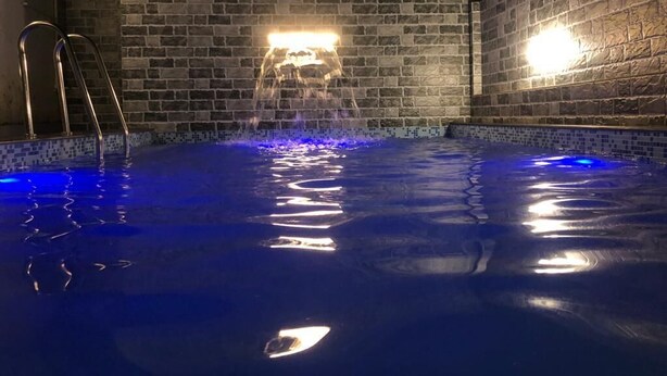 Une piscine avec un mur en briques et une échelle.