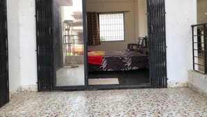 Une chambre avec un lit, un ventilateur de plafond et une fenêtre avec des rideaux.