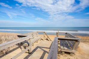 A wooden boardwalk leading to a sandy beach with the ocean in the background. - CheckMate: Walk to Beach, Large Pool, Hot Tub (Southern Shores)