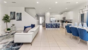 A modern apartment with a living room, kitchen, and dining area. - Entertaining Retreat with Themed Bedrooms at Encore (Kissimmee)