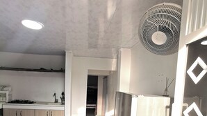Eine moderne Küche mit Kochinsel, Kühlschrank und Deckenventilator.