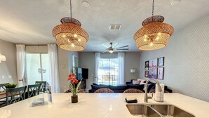 A modern kitchen with a large island, stainless steel appliances, and a ceiling fan. - Bodacious Oasis - Private Pool, Free BBQ Grill! (Champions Gate)