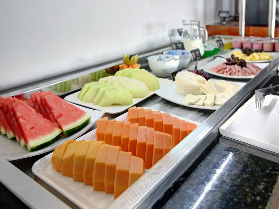 A buffet with various fruits and cheeses.
