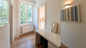 Une pièce dotée d’une grande fenêtre, d’un bureau et d’un luminaire fixé au mur.