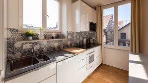 Une cuisine moderne avec un crédence à motifs noir et blanc, un évier double et un plan de travail en bois.