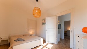 Une chambre à coucher avec un lit, une table de chevet et un luminaire suspendu.