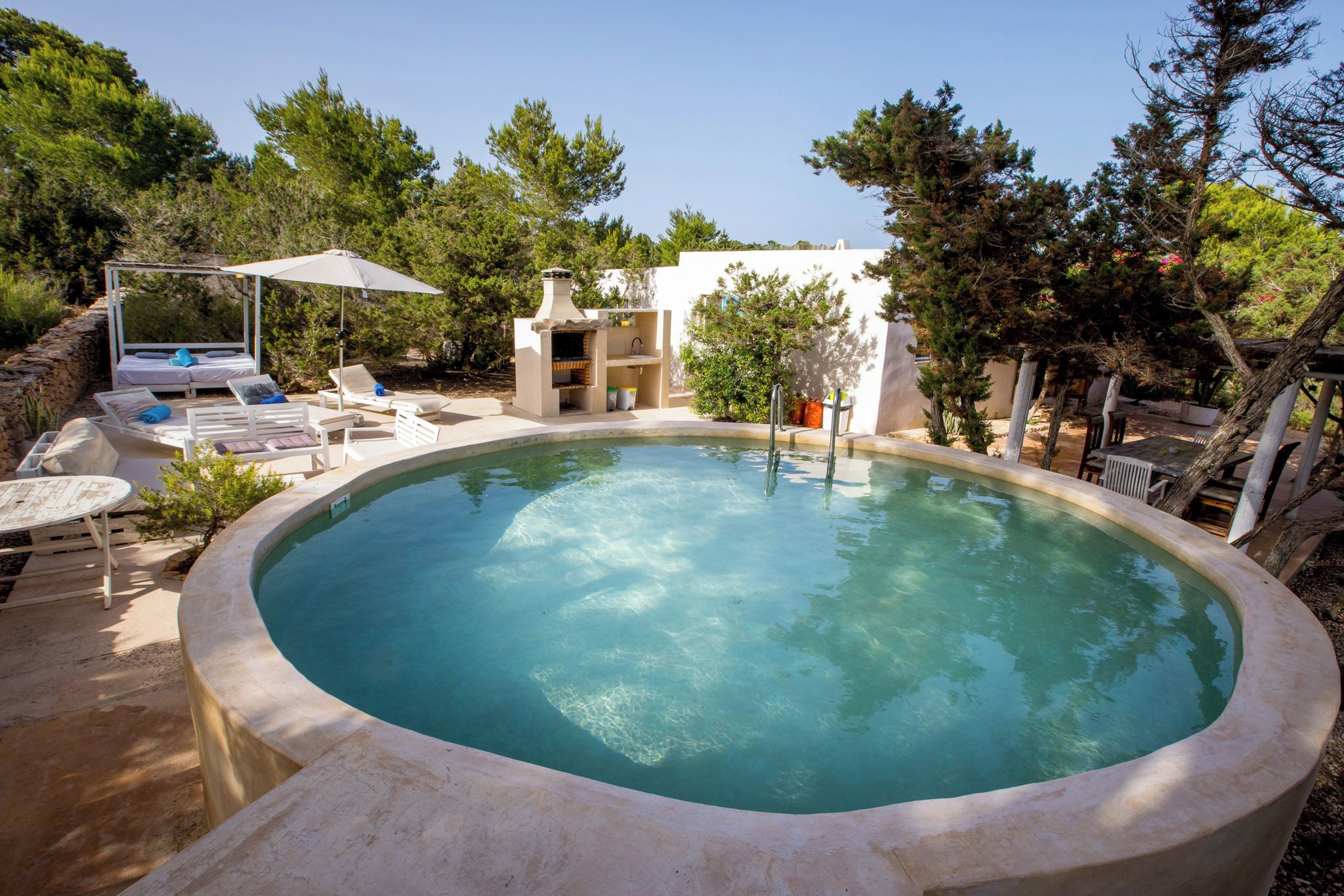 A swimming pool with lounge chairs and a barbecue area.