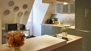 A modern kitchen with a microwave, toaster, sink, and a bowl of fruit on the counter. - Apartment SAINT-MARTIN2, in the heart of Colmar (Colmar)
