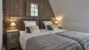 A bedroom with a sloped ceiling, wooden headboard, two bedside tables with lamps, and a large window. - Apartment SAINT-MARTIN2, in the heart of Colmar (Colmar)