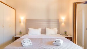 A hotel room with a large bed, two bedside tables, and a wardrobe. - Lemon Tree Corfu Apartments by Konnect (Corfu)