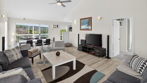 Amplia sala de estar con televisor, zona de estar y balcón con vistas.