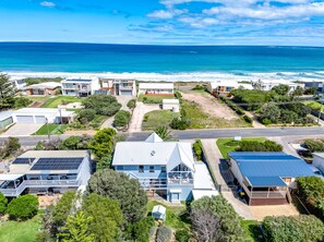 An aerial view of a coastal residential area with houses, a road, and a beach. - Surf Lovers - 28 Seagull Ave, Chiton (Chiton)