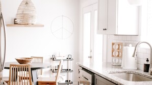 Una cocina moderna con armarios de madera, una mesa de comedor redonda y una lámpara colgante.