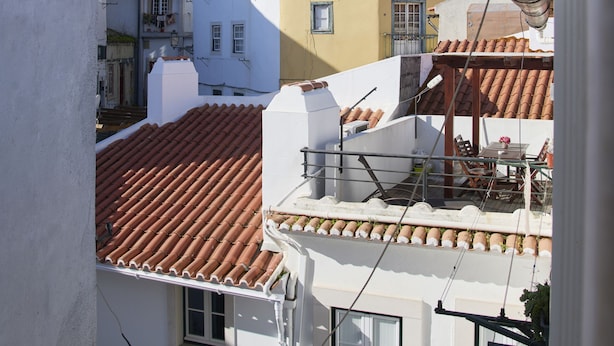 A view of a residential area with buildings featuring red-tiled roofs and balconies. - 3 guest apartment in the center of Alfama (Lisboa)