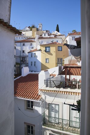 A view of a residential area with buildings featuring red-tiled roofs and balconies.