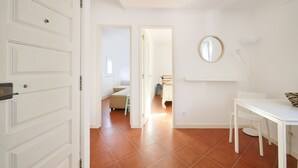 A room with a white door, a round mirror, a white desk, and a chair. - 3 guest apartment in the center of Alfama (Lisboa)