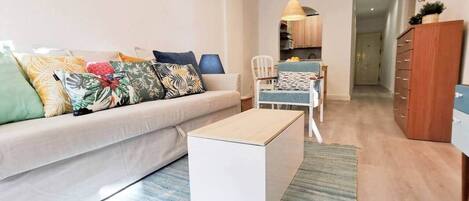 A modern living room with a sofa, coffee table, and dining area.