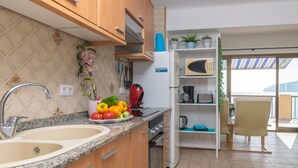 Une cuisine dotée d’un plan de travail en granit, d’un évier double, de meubles en bois et d’un four à micro-ondes encastré.