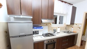 Una cocina equipada con refrigerador, estufa, horno y lavaplatos.